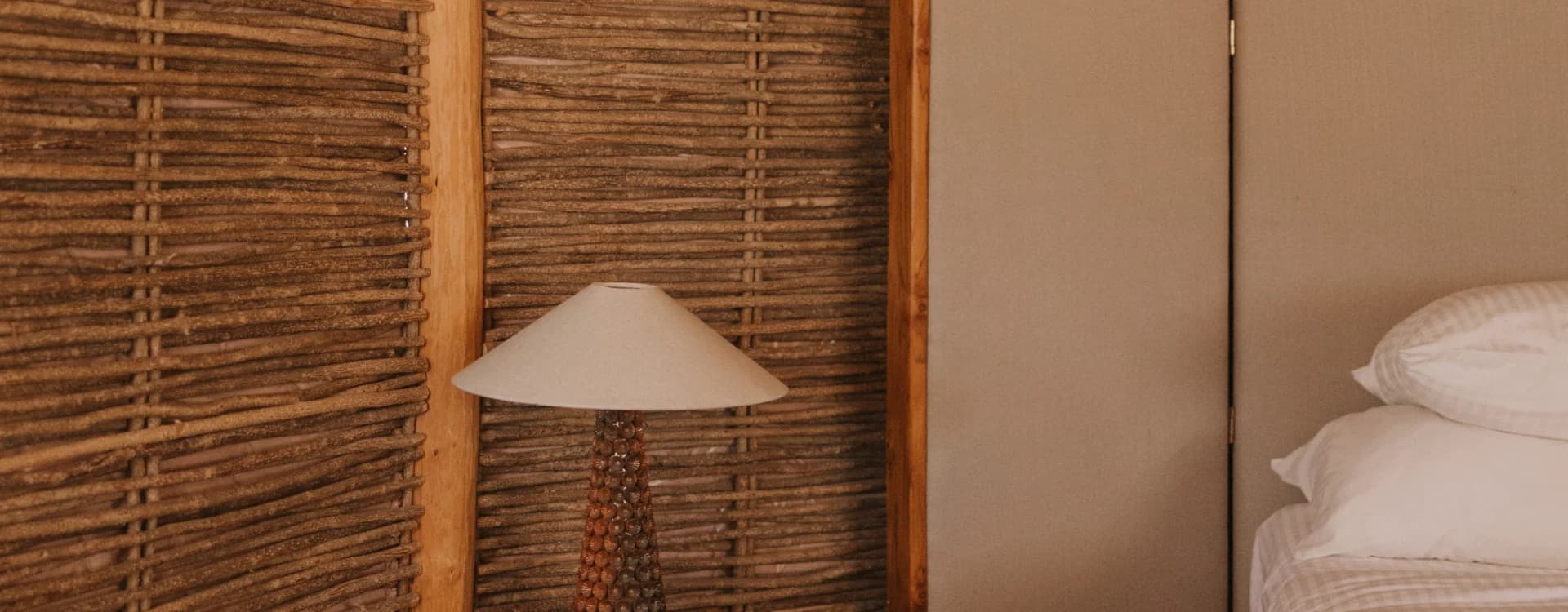 Muro de carrizo con lámpara y cama junto a la puerta