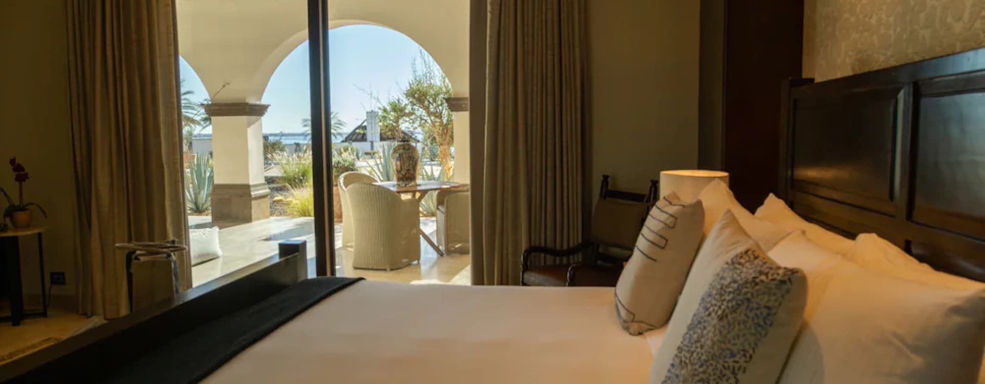Bed with cushions facing the window onto the terrace