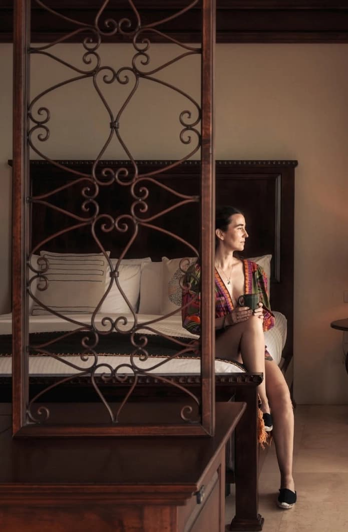 Cama de dosel de herrería detrás de un biombo de forja