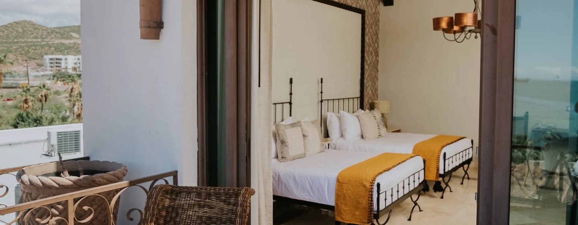 Room seen from the terrace, with wicker armchairs and open sliding doors
